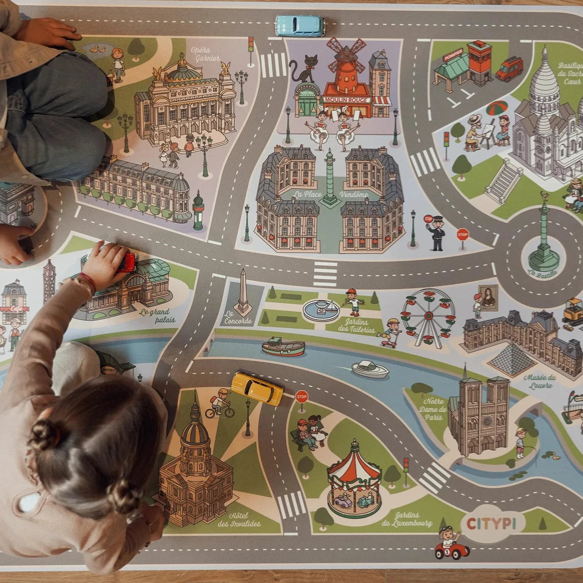 Deux enfants sont en train de jouer sur un tapis de jeu pour petites voitures